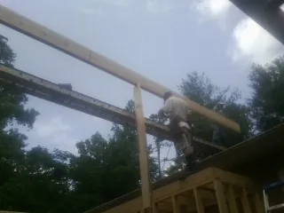 Carpenter setting a ridge beam over a new addition frame — Ice Dam Removal by Roofing Brothers in Twin Lake
