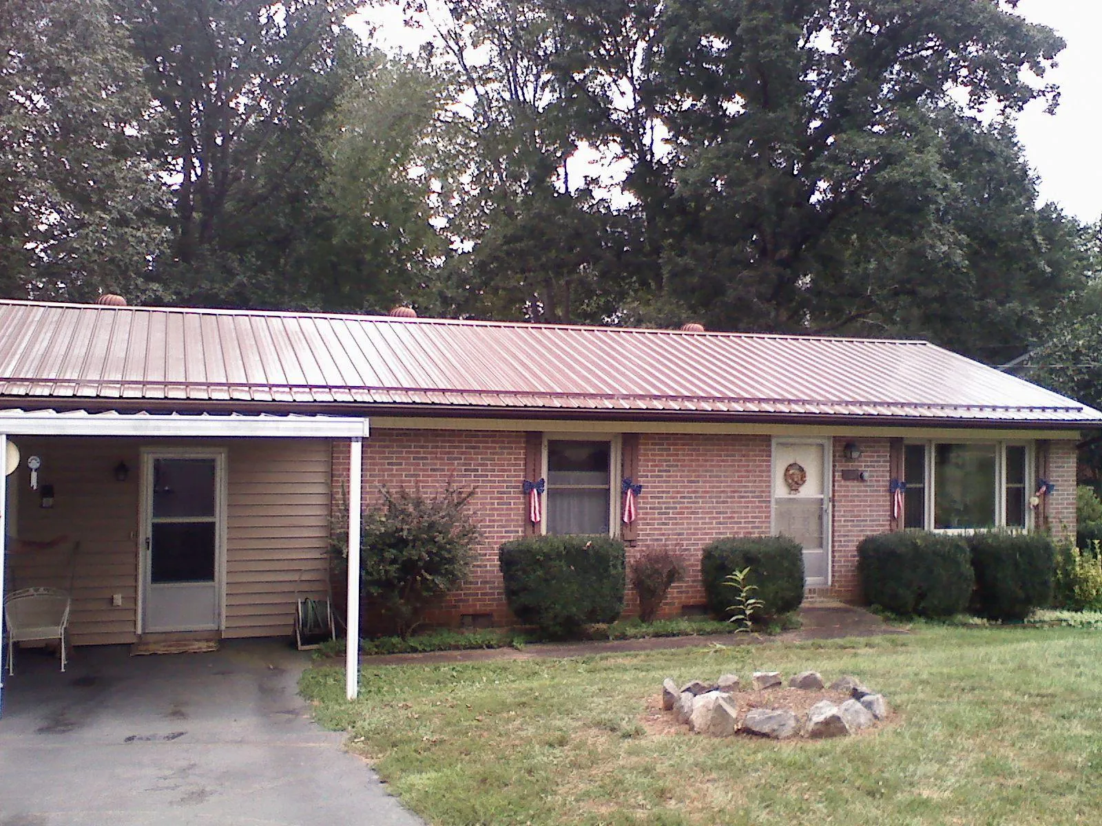 Bronze metal roof and carport on a brick ranch home — Roof Repair work by our crew in Twin Lake
