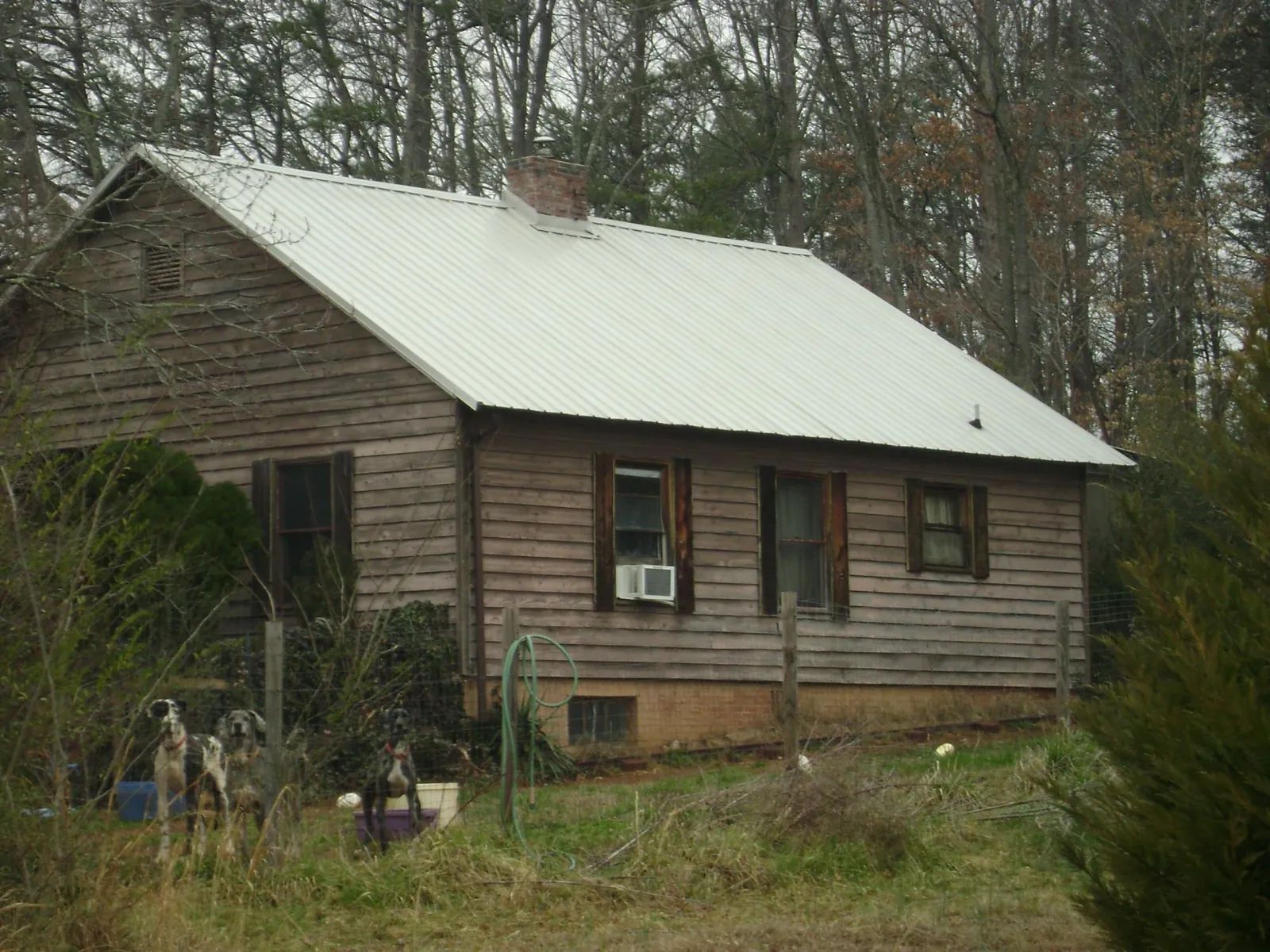 White metal roof on an old wood sided farmhouse, from a Metal Roof Installation job in Twin Lake